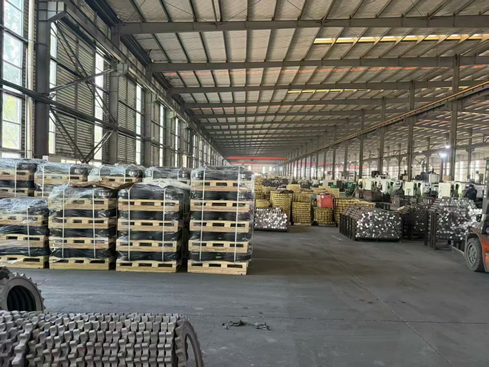 Palletized undercarriage parts in an industrial warehouse environment